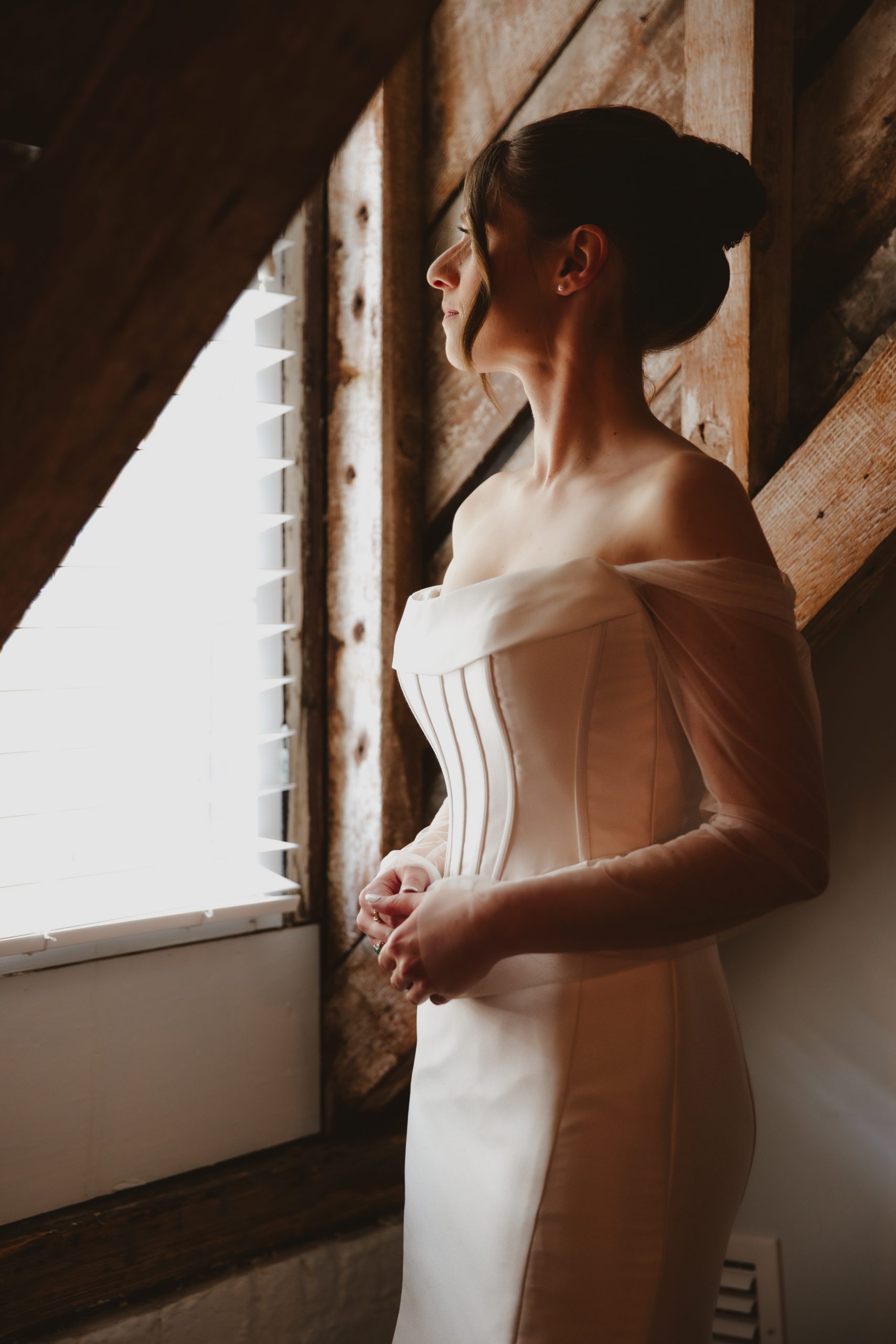 7Q6A6004 Charleston bride looks out window on her wedding day